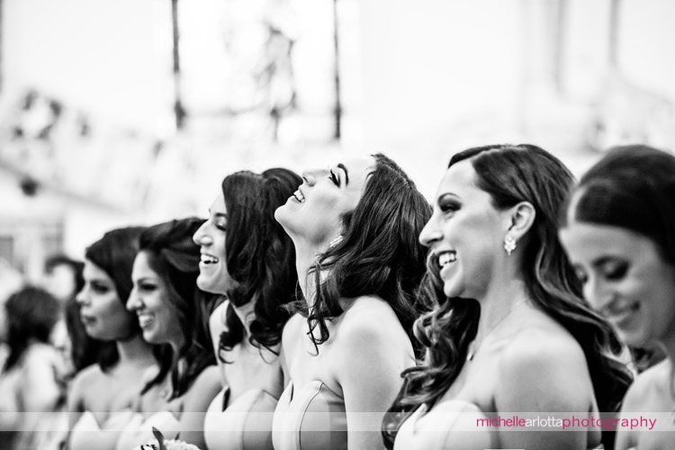 bridesmaids in white runway dresses laugh during nj wedding ceremony