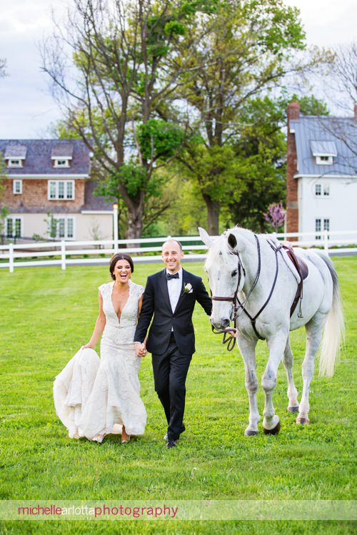 landmark venues Ryland inn equestrian ring with bride wearing berta wedding dress and groom walking with horse