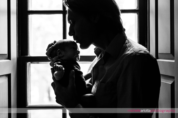 father about to kiss newborn son's forehead