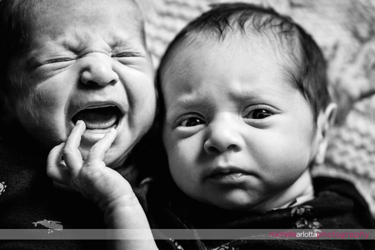 newborn girl grabs face of her brother to console him as he cries newborn photography