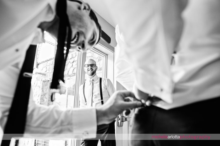 groomsmen help each other out with suspenders in rock island lake club's groom suite
