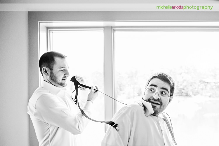 groomsmen has shocked face as groom pulls his suspenders back