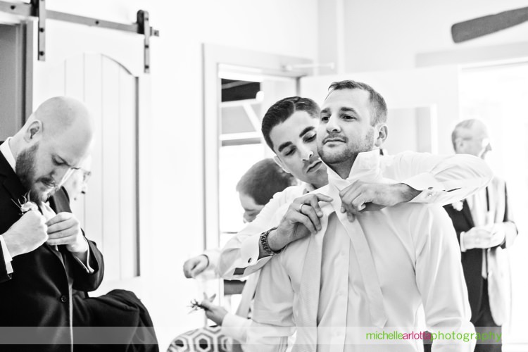 groom gets help tying his tie