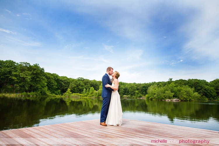 Sarah seven bride and groom kiss on dock at super chill rock island lake club wedding