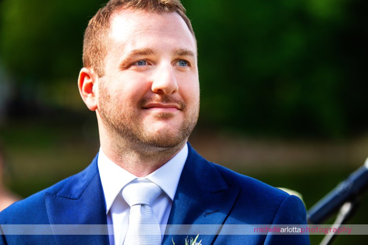 groom in blue suit watches as his bride walks down the aisle for nj wedding