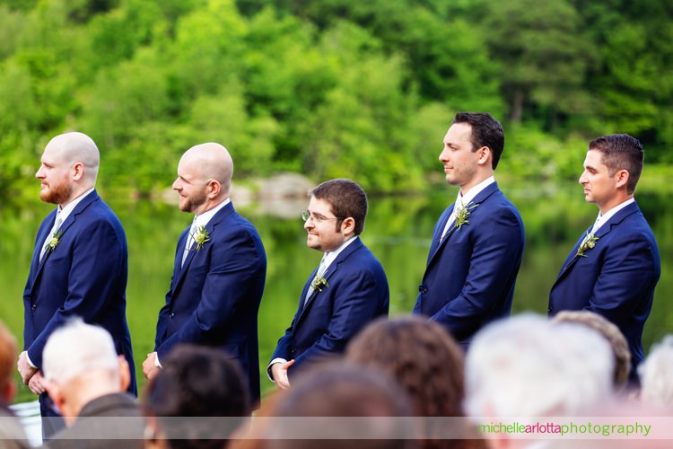 groomsmen watch wedding ceremony on lake in New Jersey