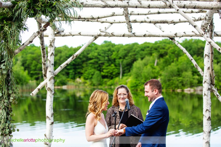 bride wearing Sarah seven exchanges rings during rock island lake club lakeside wedding ceremony