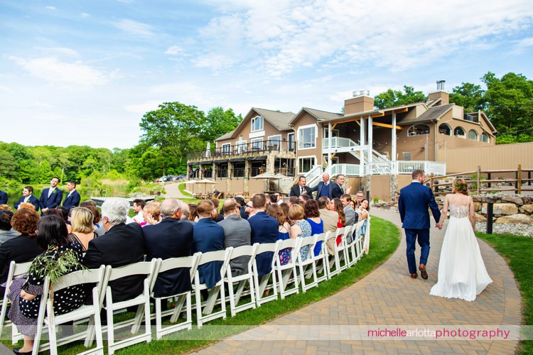 bride and groom exit their wedding ceremony at rustic super chill rock island lake club wedding