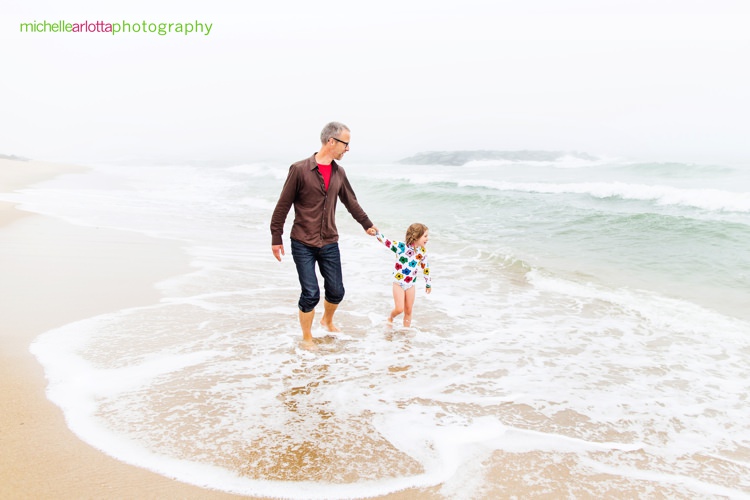 father and daughter play in the water at the nj shore for family photo session with Michelle arlotta photography
