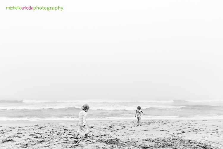 sisters runs on the beach during new jersey shore candid family photography 