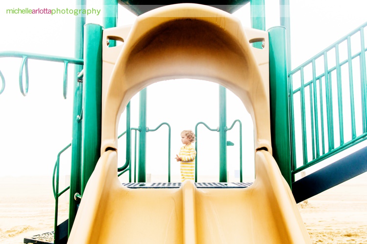 toddler at the top of slide at beach at asbury park nj
