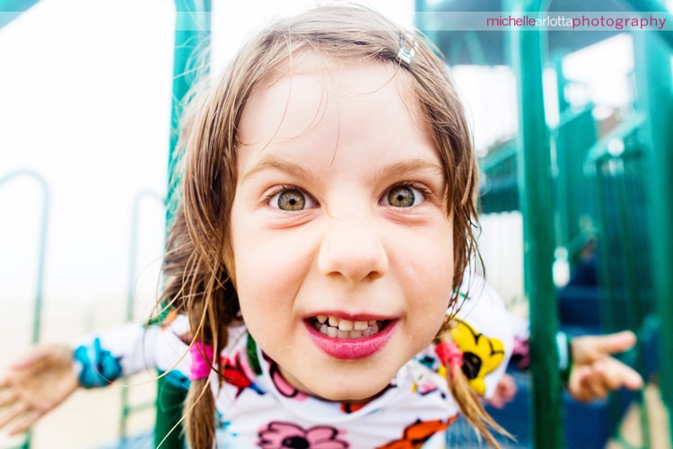 little girl makes funny face up close to the camera during family photos session in nj