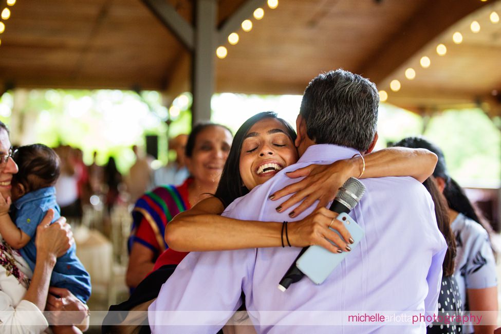 daughter hugs her dad at surprise 60th birthday party at sweetgrass pavilion