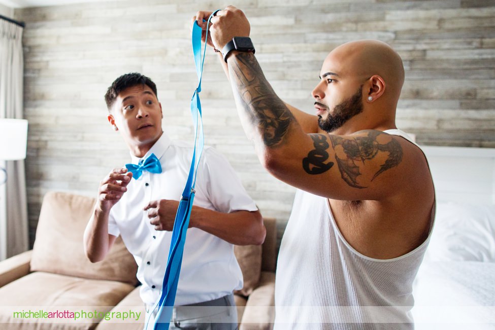 groom with blue suspenders gets ready at grand hotel cape may new jersey