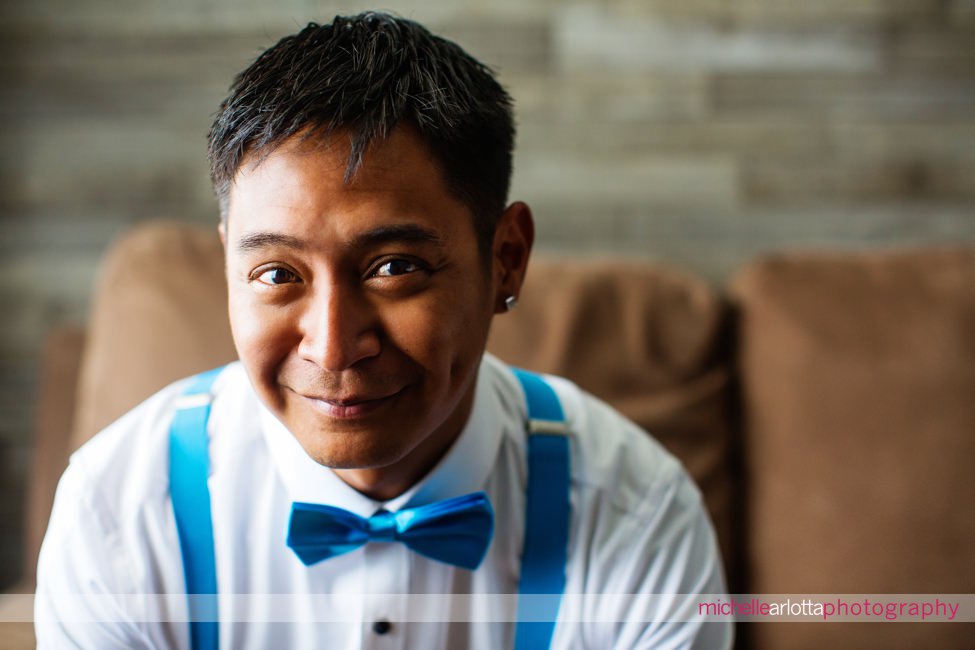portrait of groom in blue bowtie and and blue suspenders