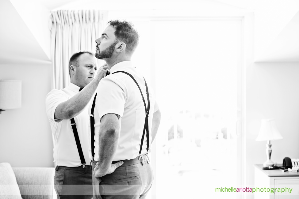 groomsmen help each other get ready for same sex wedding in cape may new jersey