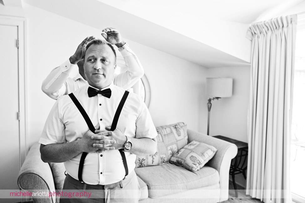 groomsmen help each other get ready for same sex wedding in cape may new jersey