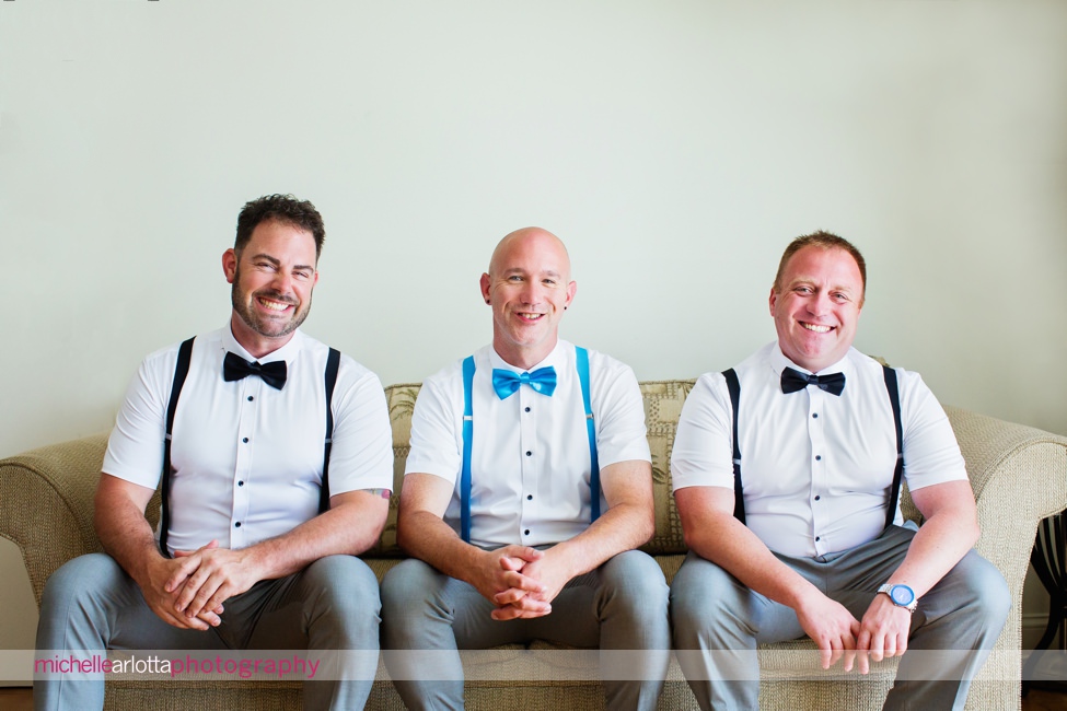groom and groomsmen laughing on couch at grand hotel cape may