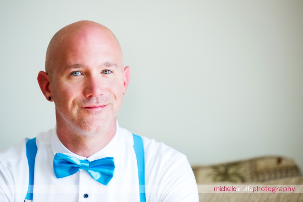 portrait of groom in blue bowtie and and blue suspenders
