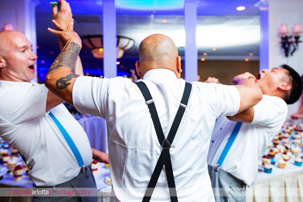 groomsmen smashes two grooms in the face with cake at cape may wedding reception