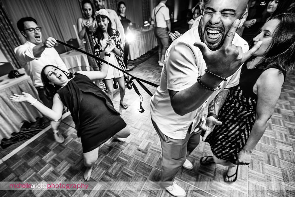 guests playing limbo with suspenders during same sex wedding couple's New Jersey shore grand hotel cape may with dj bobby lafauci of sce events
