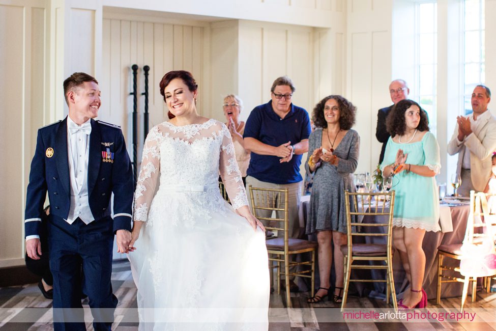 bride and groom enter their summer wedding reception at the ryland inn coach house