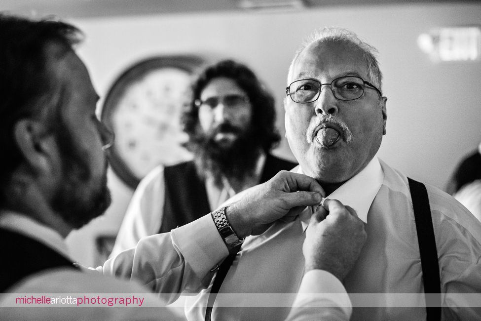 groomsmen sticks his Tongue out for the camera while getting ready in woodford lounge bear brook groom prep