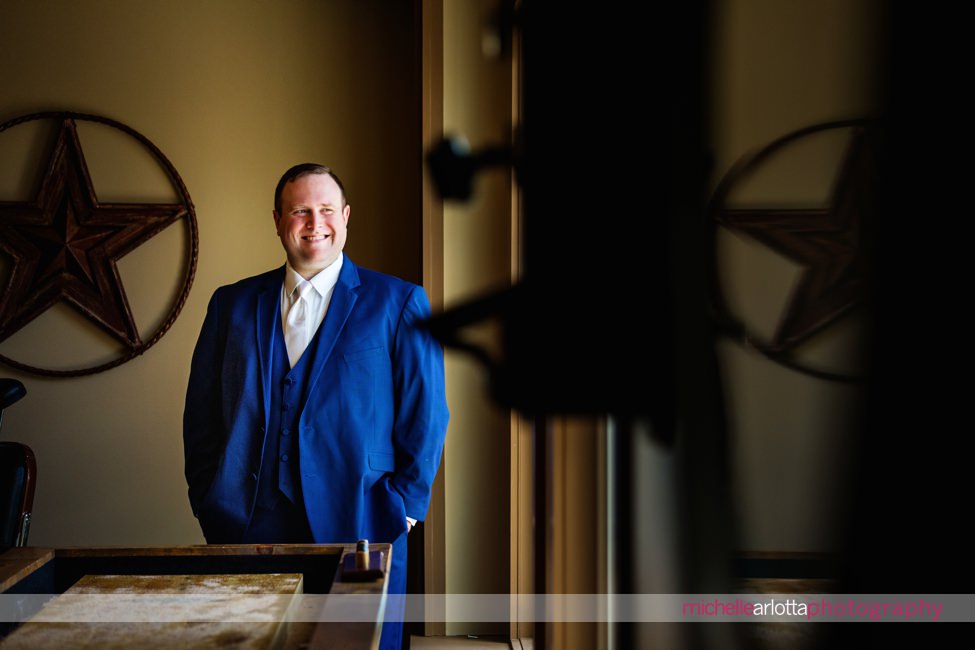 portrait of groom in blue suit in Woodford lounge of bear brook valley wedding venue