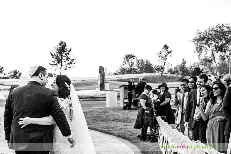 bride and groom walk away from ceremony together at New Jersey wedding ceremony