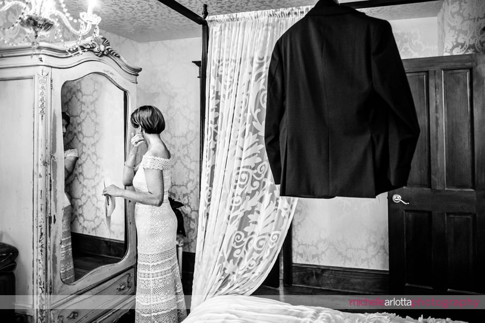 bride in bhldn dress checks her earrings in mirror of gables inn lbi