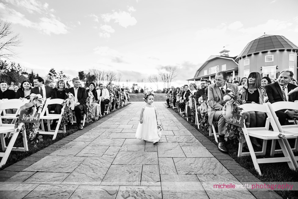 flower girl walks down the aisle for bear brook valley outdoor fall nj wedding ceremony