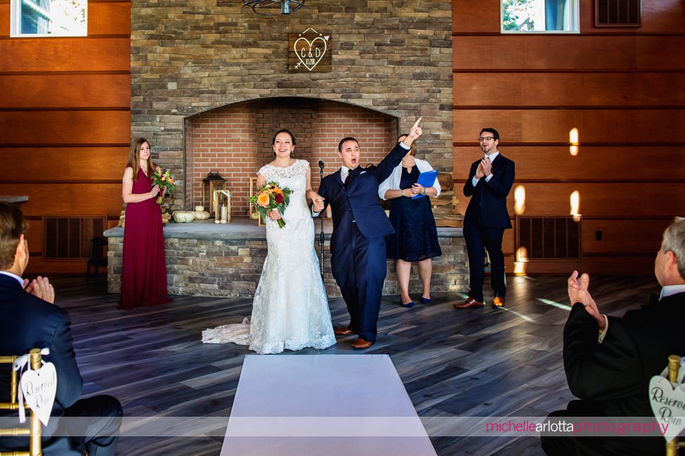 lodge at stirling ridge stone house New Jersey indoor wedding ceremony groom cheering at end of ceremony