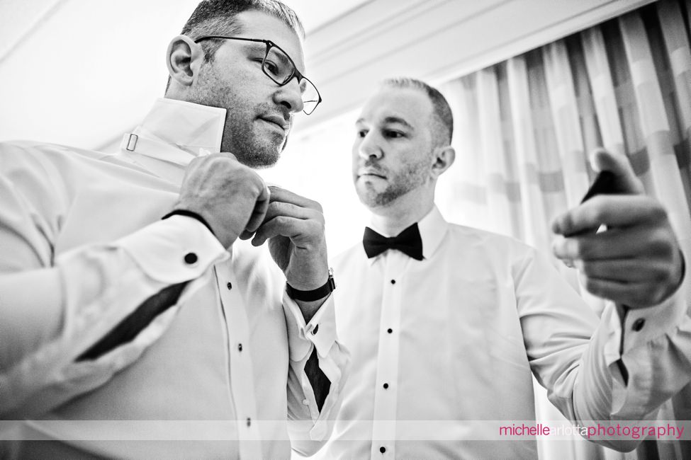 New Jersey wedding brother holding phone while groom watches video on how to tie a bowtie