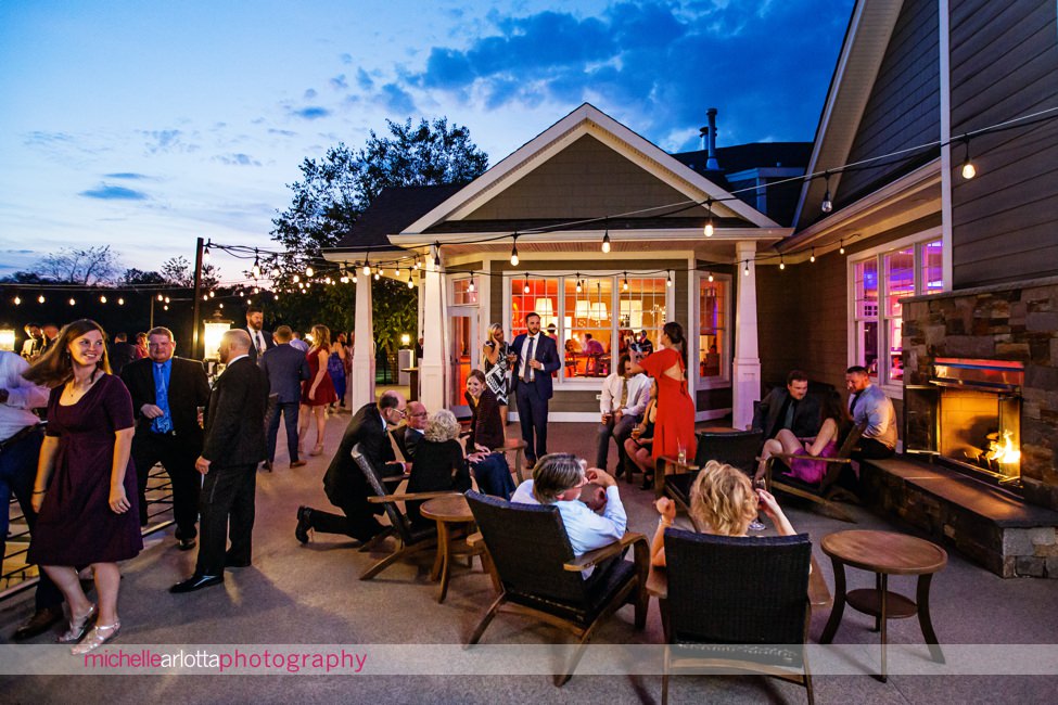 bear brook valley autumn wedding nj reception guests enjoying patio and outdoor fireplace