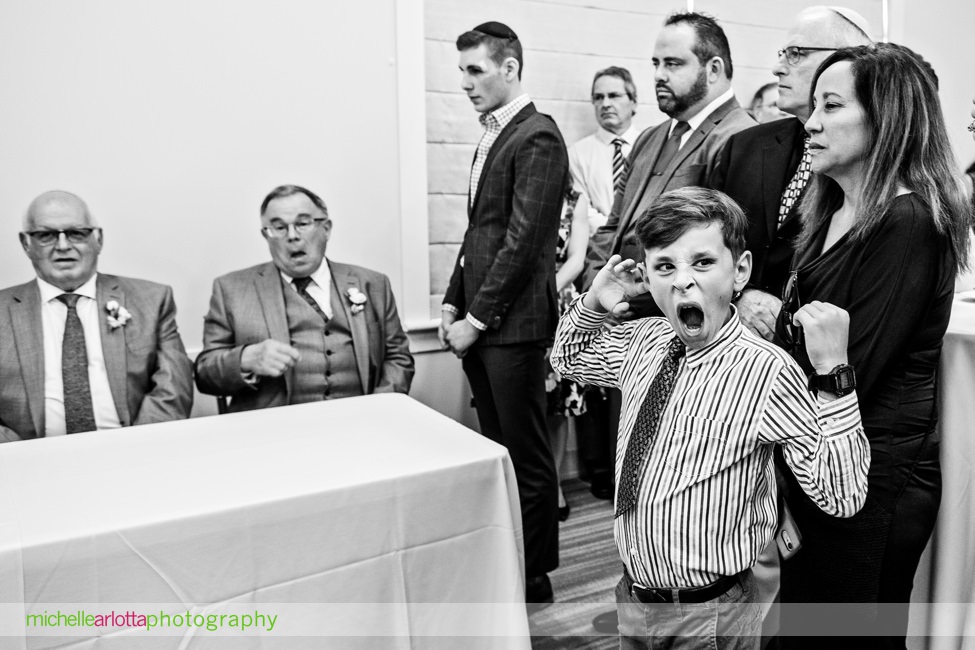 boathouse at mercer lake wedding New Jersey kid yawning during ketubah signing