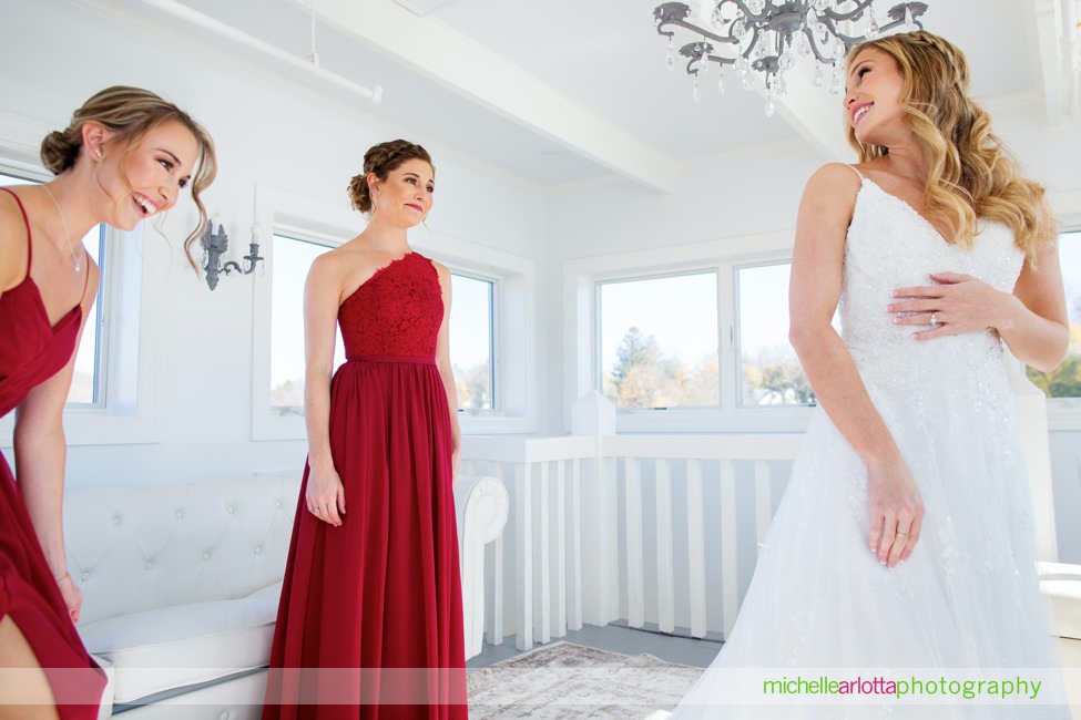 lake mohawk country club bridesmaids in red dresses help bride get dressed