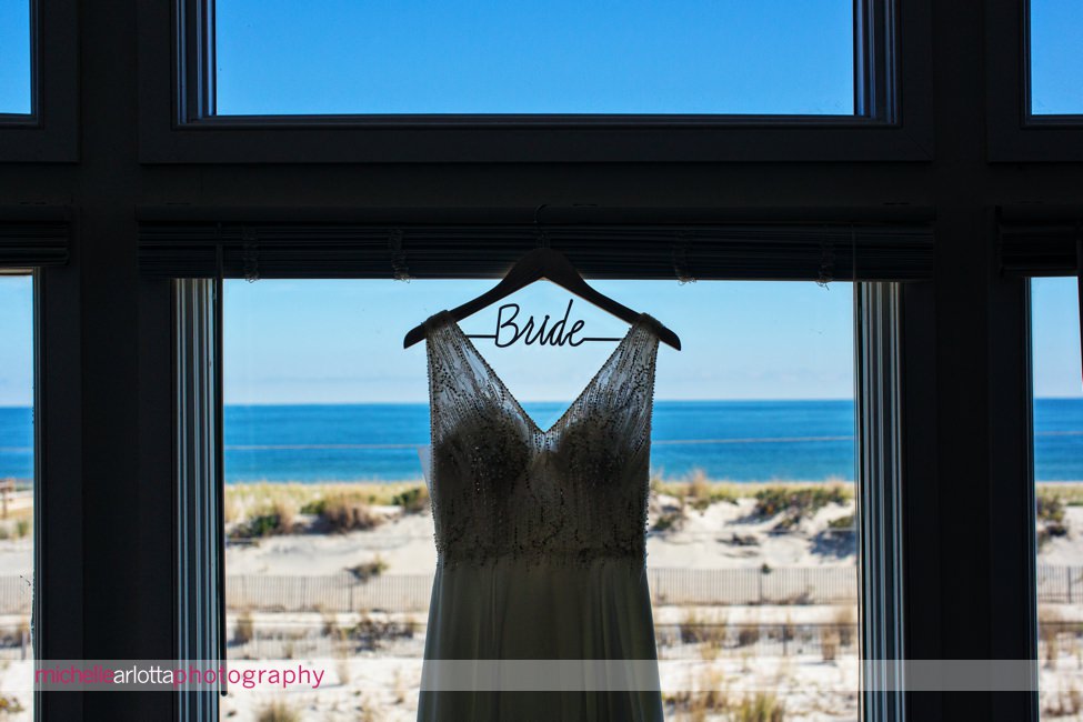 Martell's water's edge New Jersey wedding bride prep dress in window with beach behind