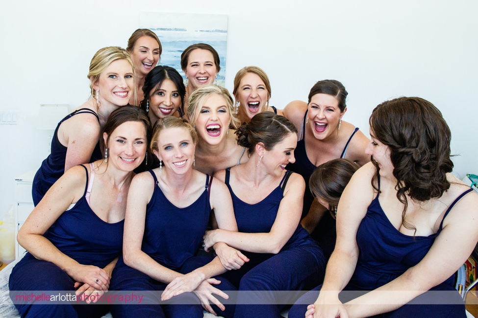 Martell's water's edge New Jersey wedding bride prep bridesmaids in jumpers laughing during picture