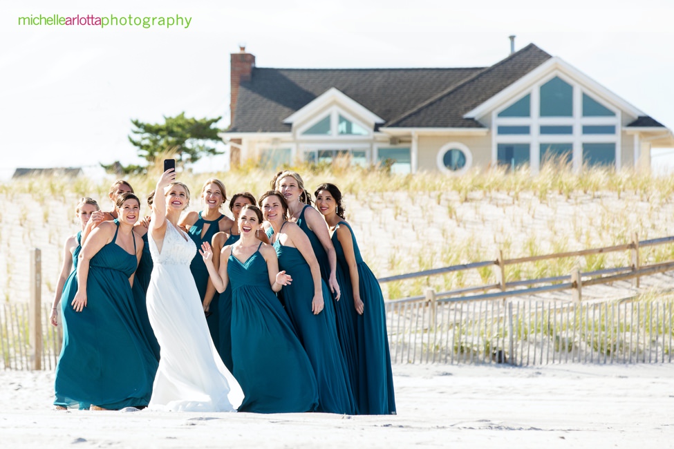 Martell's water's edge New Jersey wedding bride and bridesmaids taking a selfie on the beach