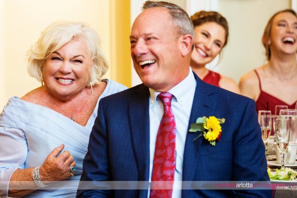 groom's parents laugh during Lake Mohawk country club wedding toasts