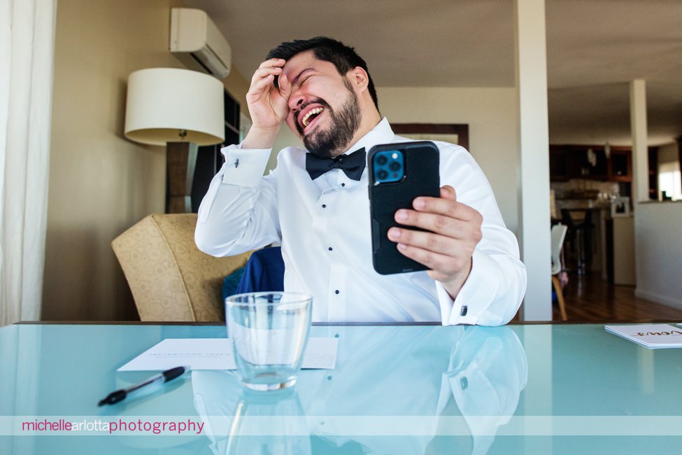 San Diego intimate wedding groom laughing while FaceTiming with family back home