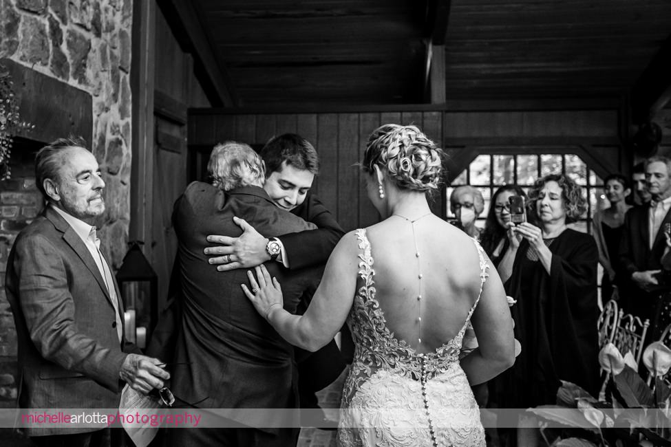 Waterloo village indoor wedding ceremony groom hugs father of the bride