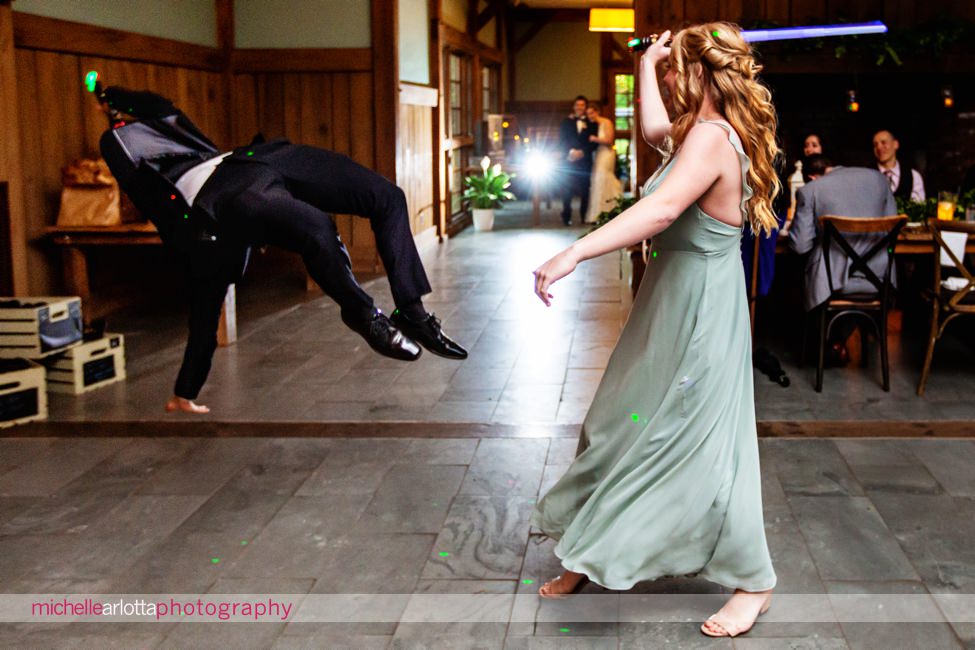 Waterloo village wedding reception groomsmen flips in air during entrance