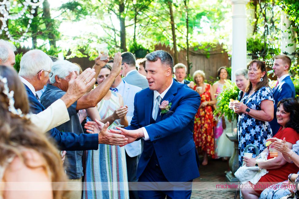 LBI gables NJ outdoor wedding reception bride and groom enter giving high fives