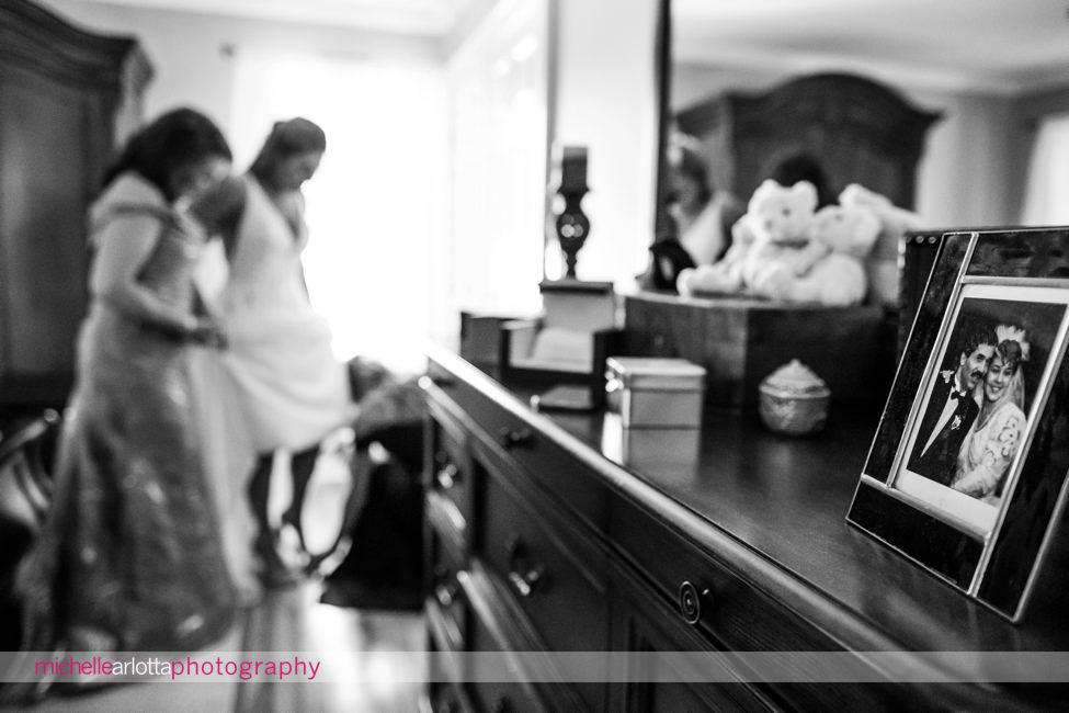 The Farmhouse wedding nj bride getting into shoes with help of mother and sister