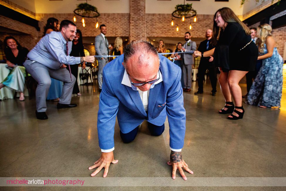 refinery at perona farms NJ wedding reception tie limbo man crawling on ground