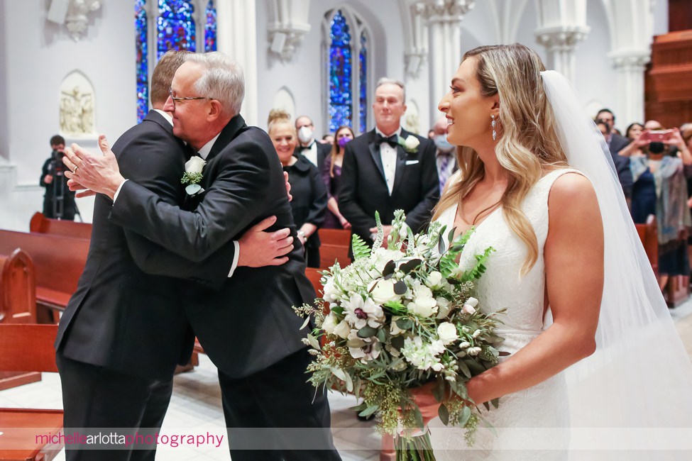 St. Thomas of Villanova church wedding father hugs groom at altar with bride