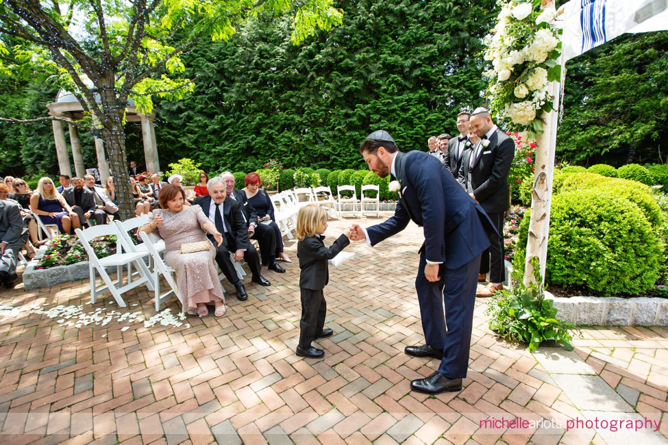outdoor NJ wedding ceremony at Florentine Gardens groom fist bumps ring bearer