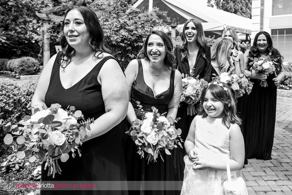 outdoor NJ wedding ceremony at Florentine Gardens bridemaids smiling as bride arrives at altar