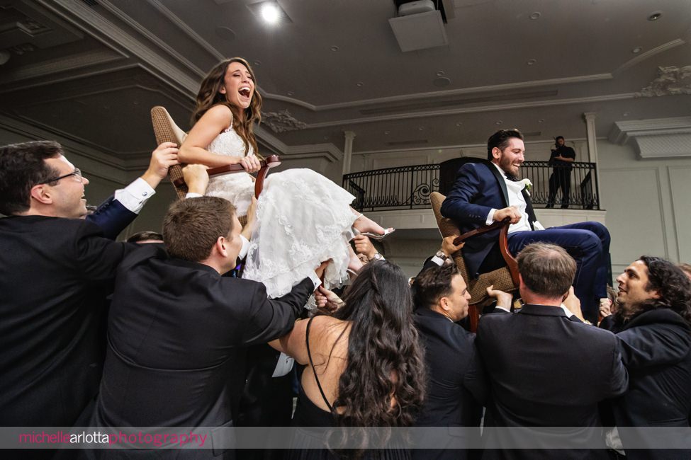 estate at Florentine Gardens nj wedding reception bride and groom in chairs during the horah